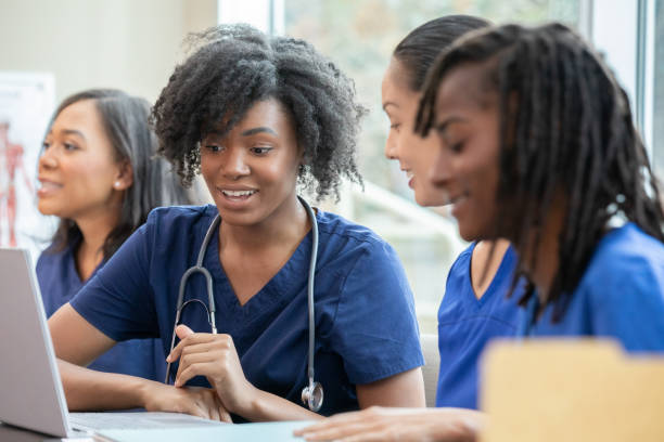 Young medical student studying nursing with classmates uses laptop during class
